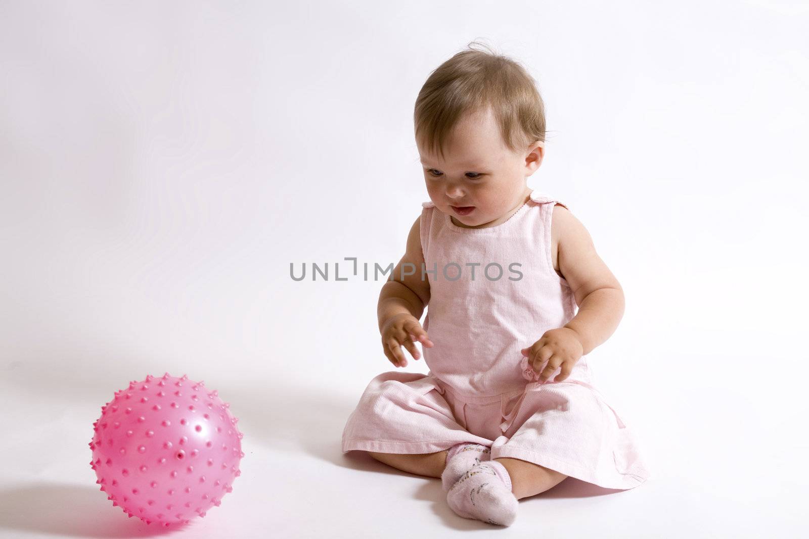 eight month baby playing with pink ball