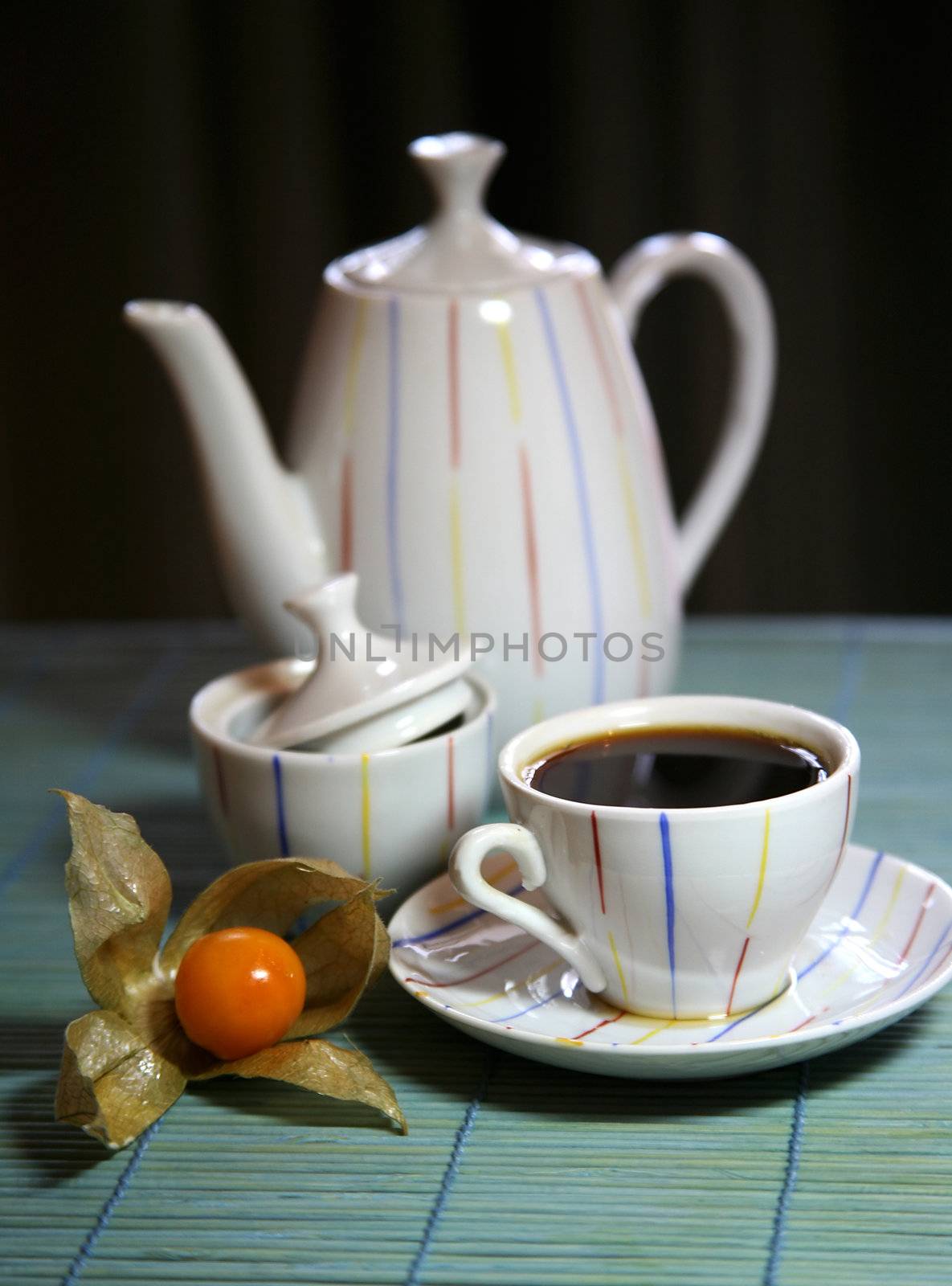 Two cups and a teapot on a green wooden napkin