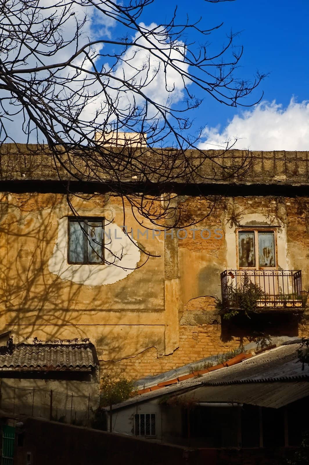 Decayed house facade with window and balcony