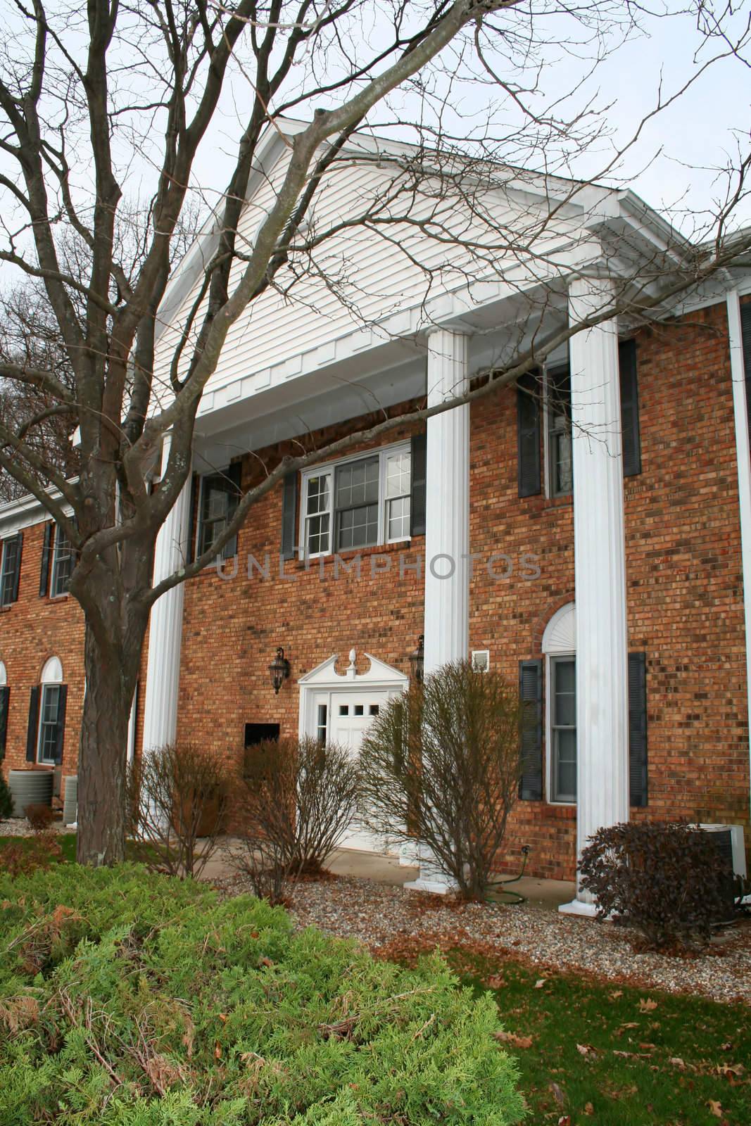 Exterior shot of a brick building with large, white pillars.