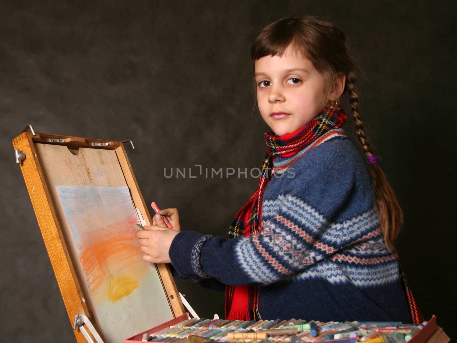 The girl draws paints in studio