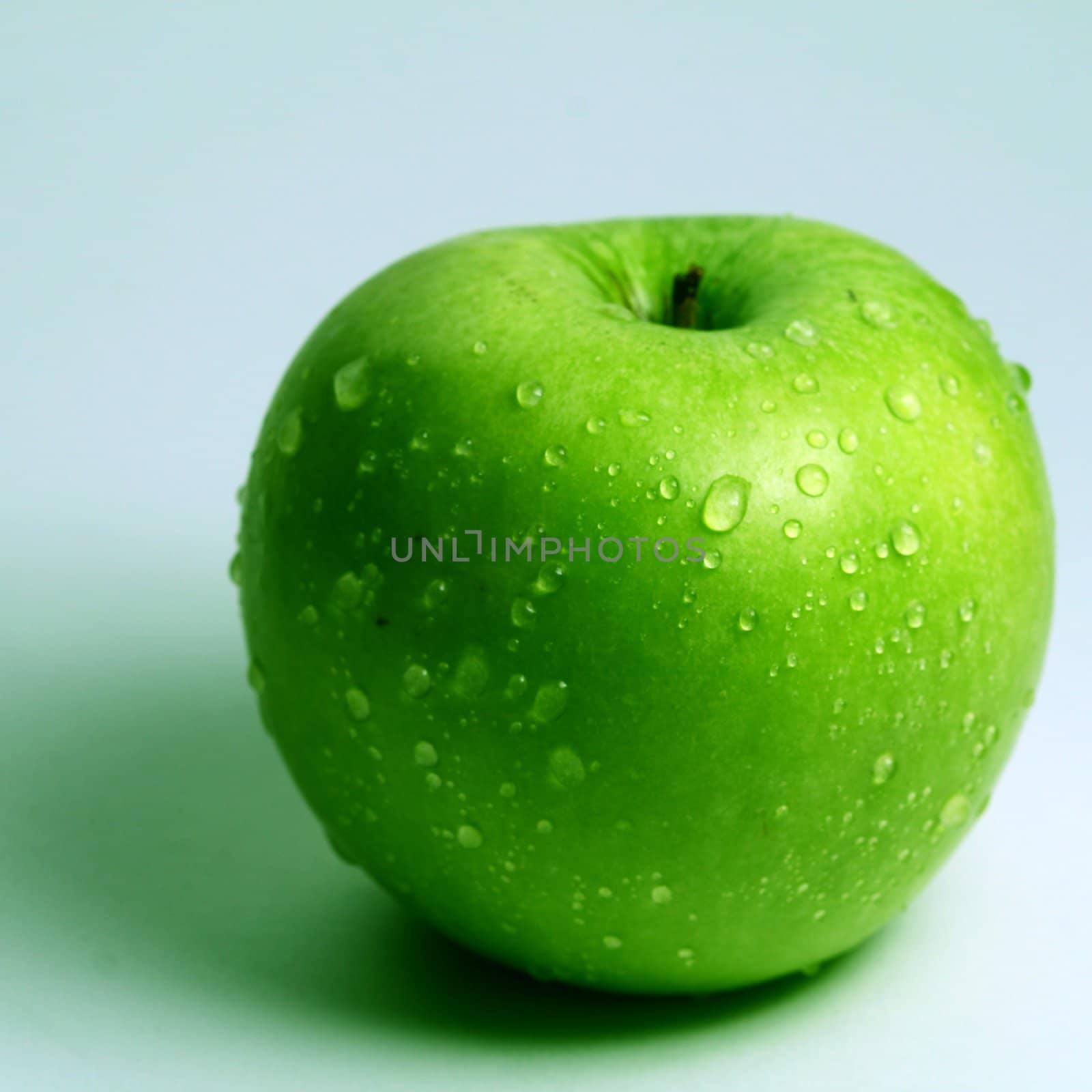 green fresh apple and waterdrops from it