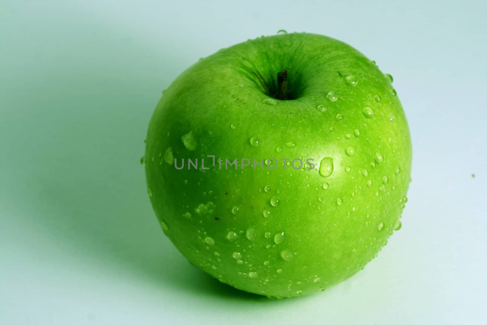 green fresh apple and waterdrops from it