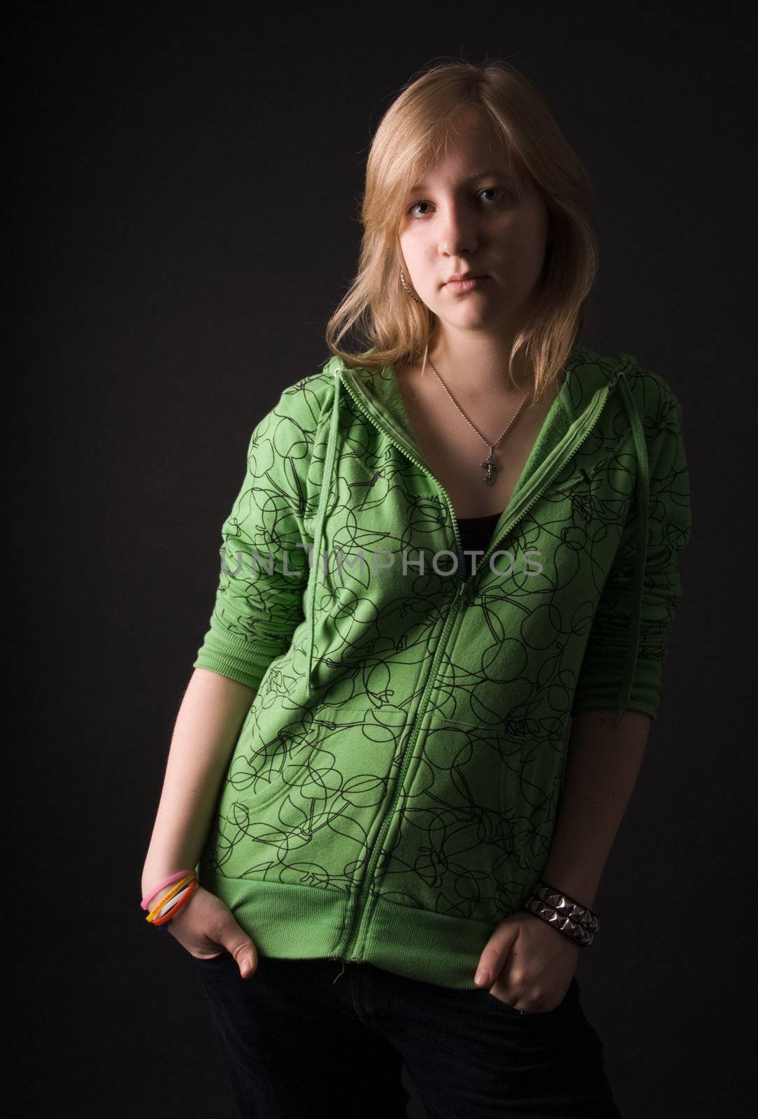 The young girl in green clothes on a black background.