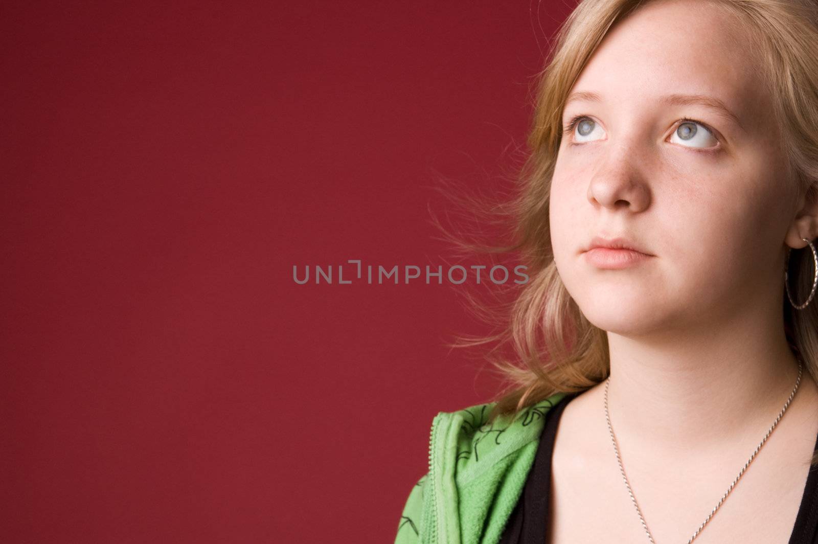 The young girl in green clothes on a red background.