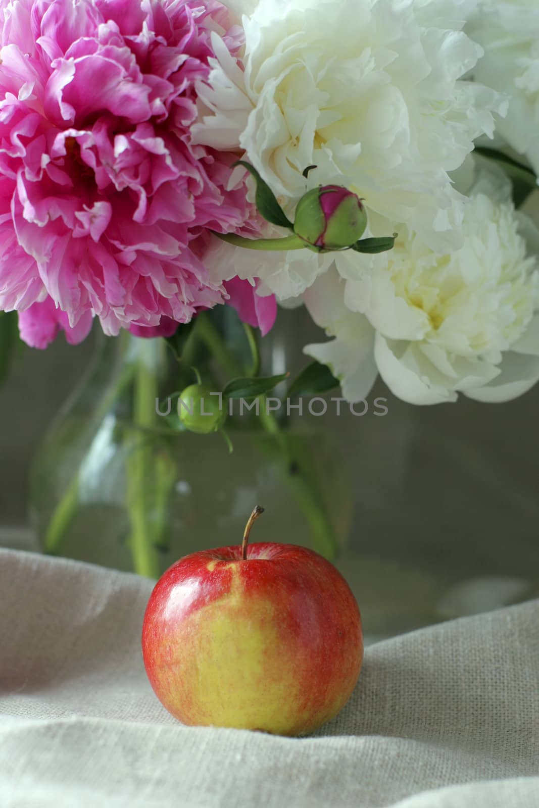 Flowers and apple on the table.