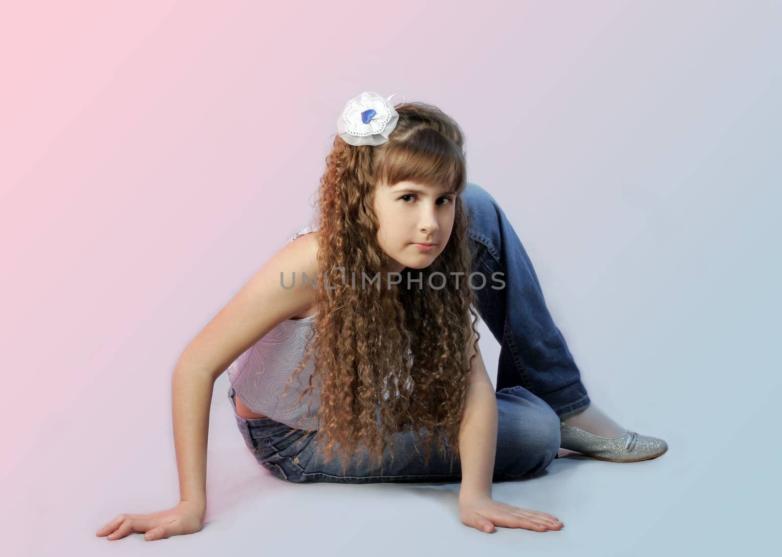 Girl with long and curly hair sits on floor