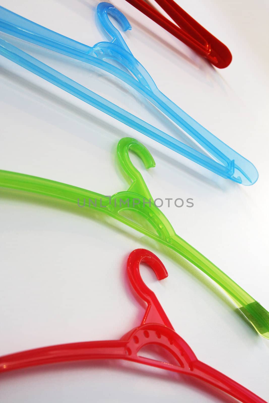 Colored plastic coat hangers on a wall. Bottom view.