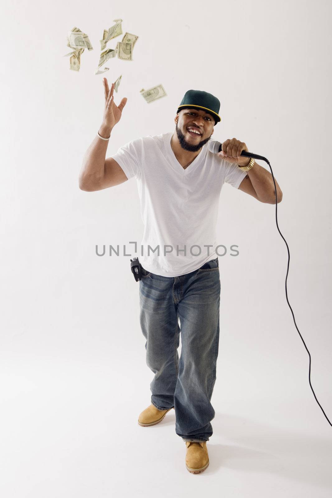 Black vocalist singing into microphone tossing money in the air