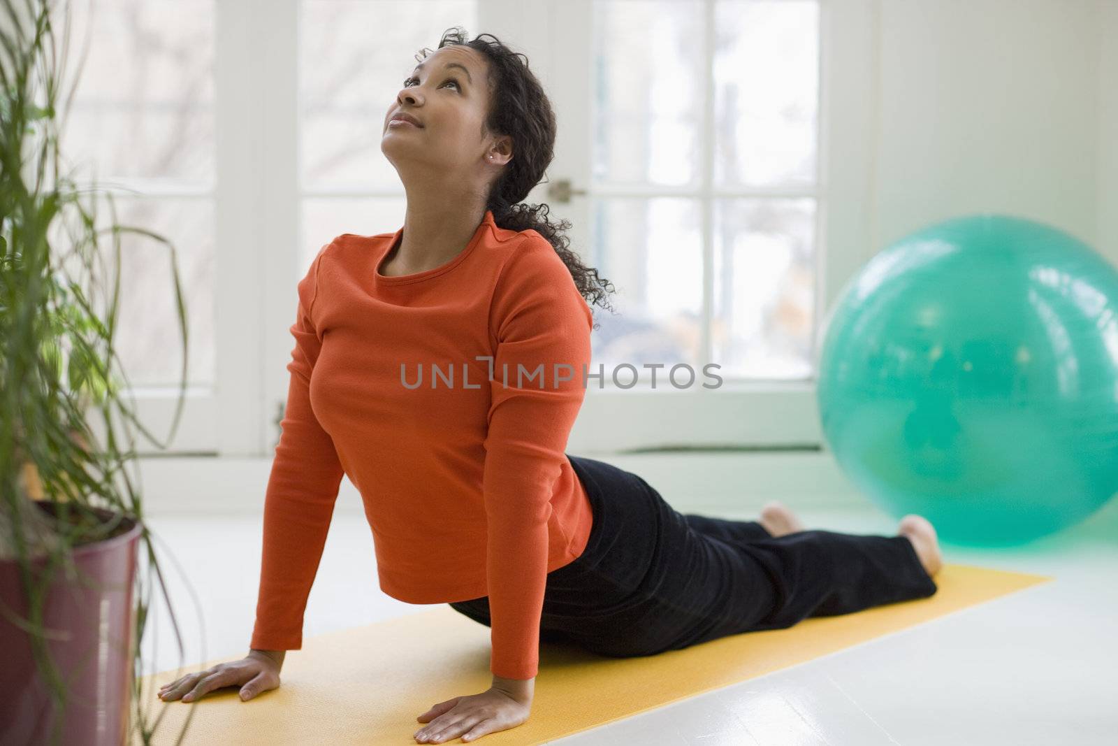 Pretty black woman practicing yoga by edbockstock
