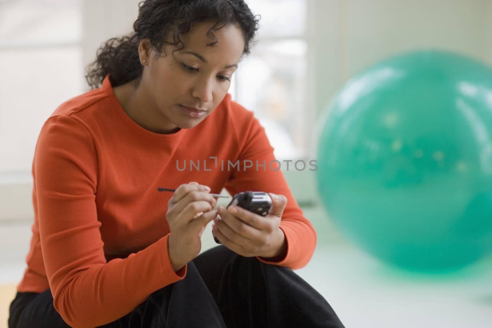 Young African American woman text messaging on cell phone 