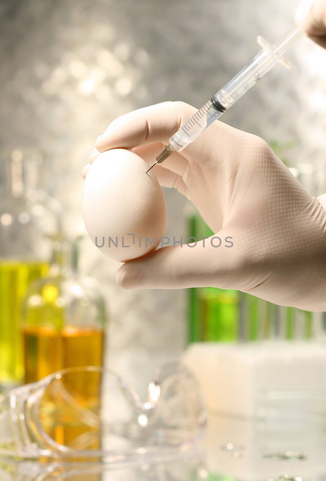 Close-up of syringe injecting egg  by Sandralise