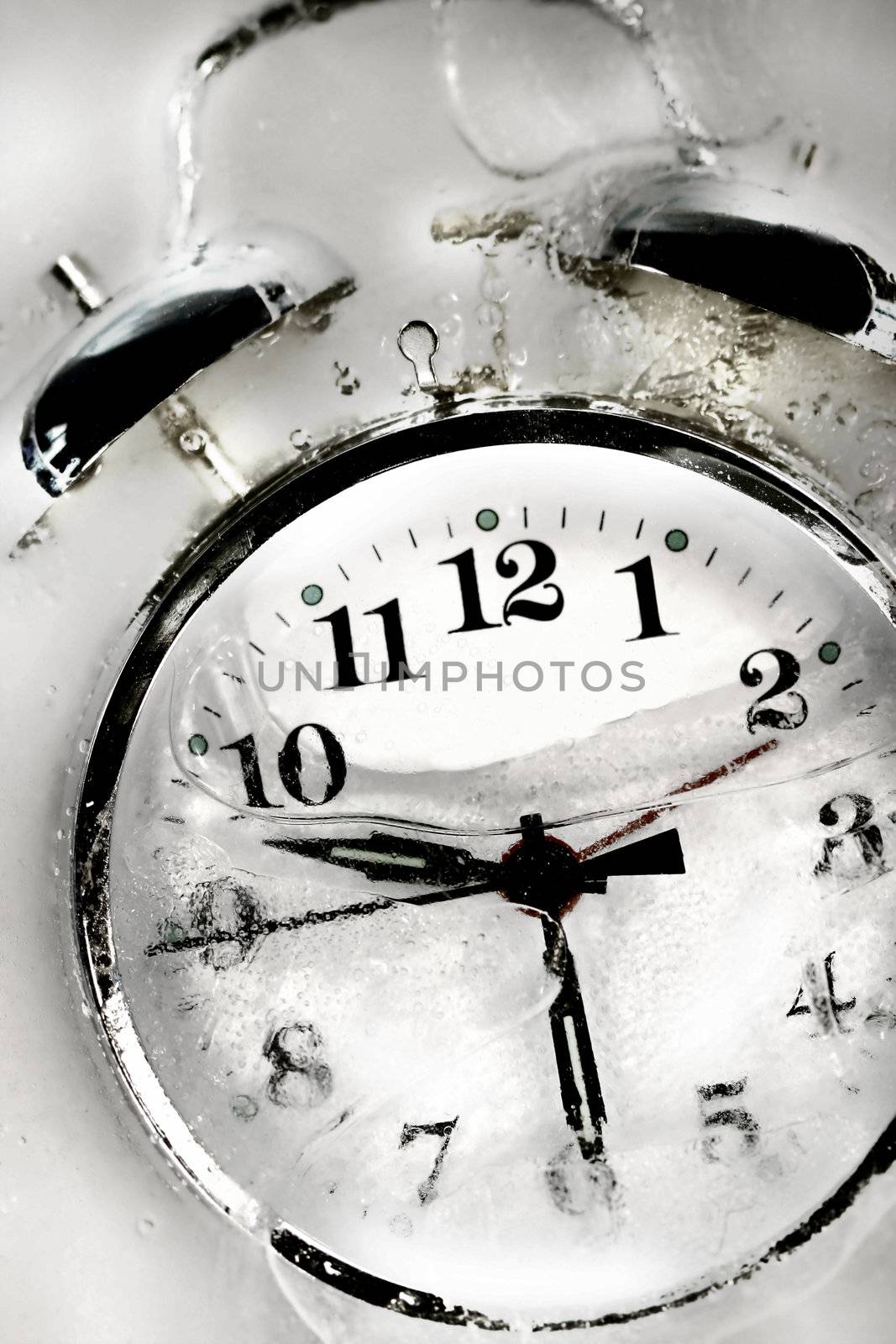 Alarm clock with hands set frozen in the ice/BW