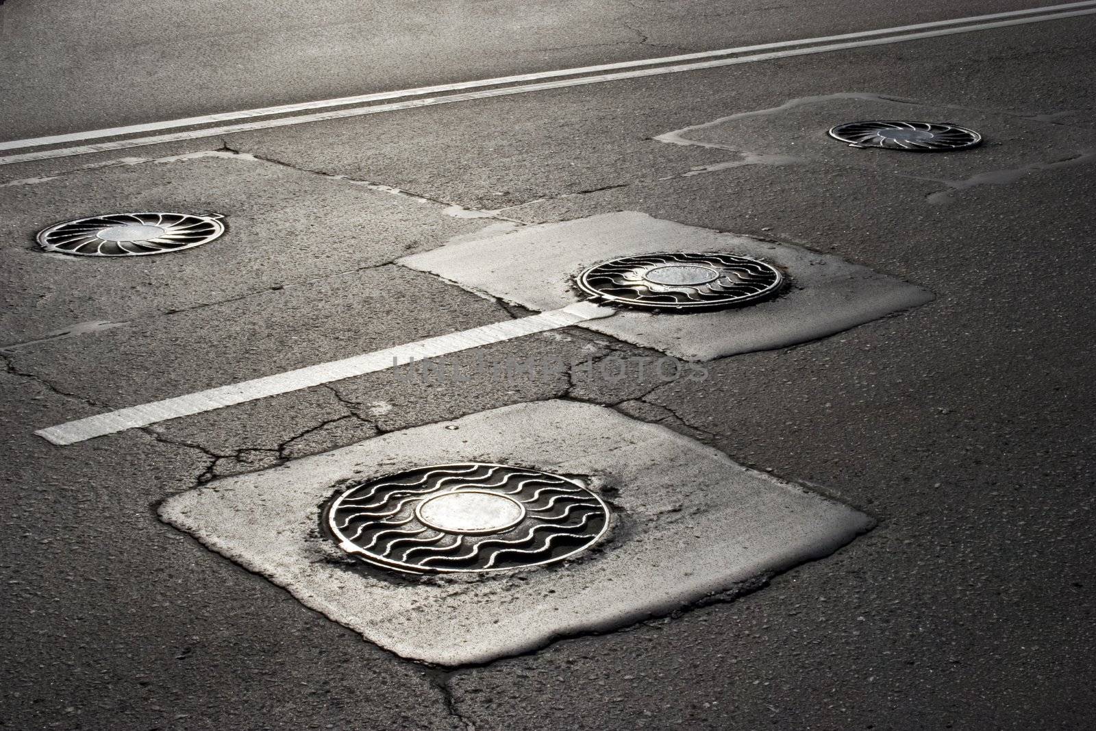 Three manhols on the road in Moscow city. Russia.