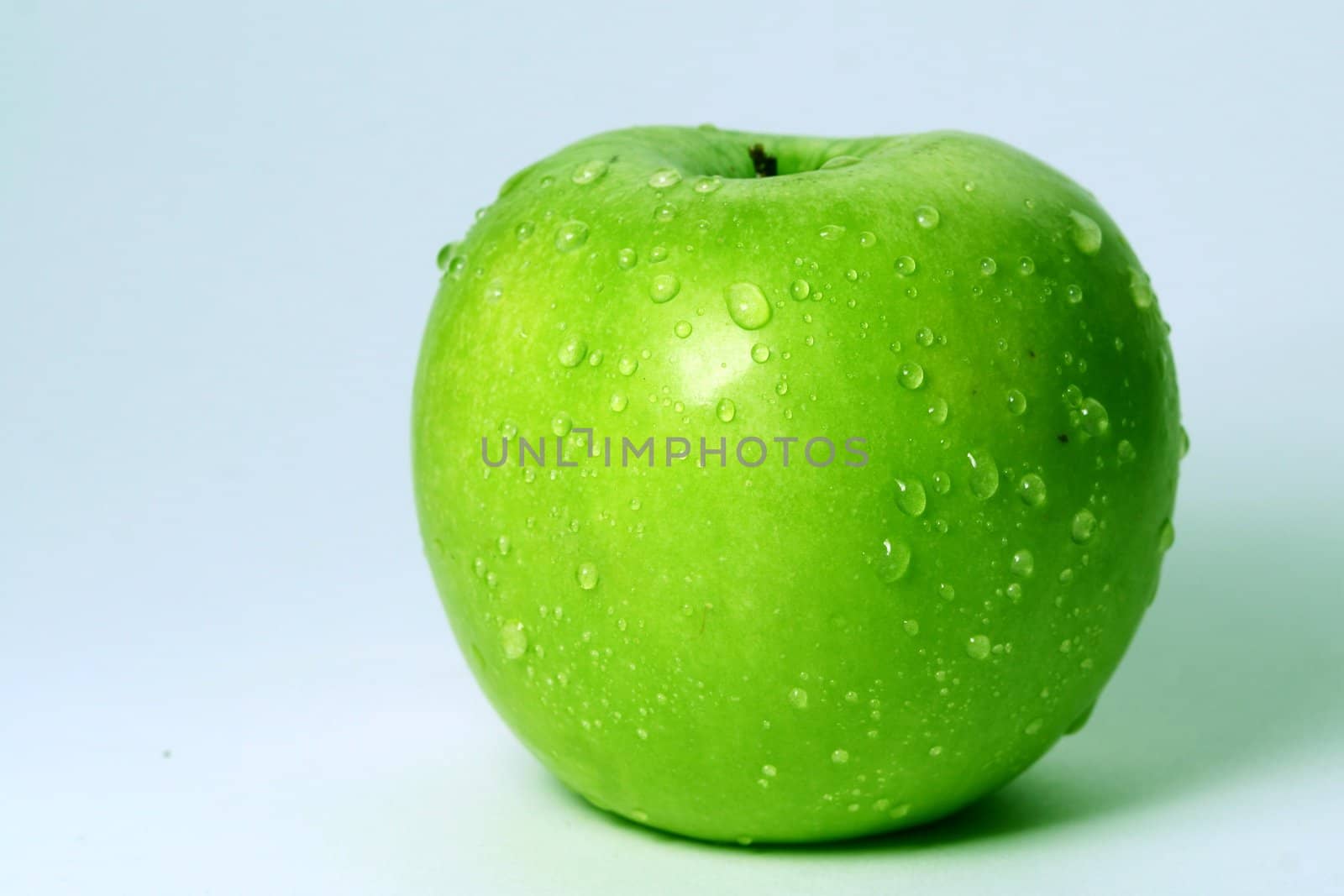 green fresh apple and waterdrops from it