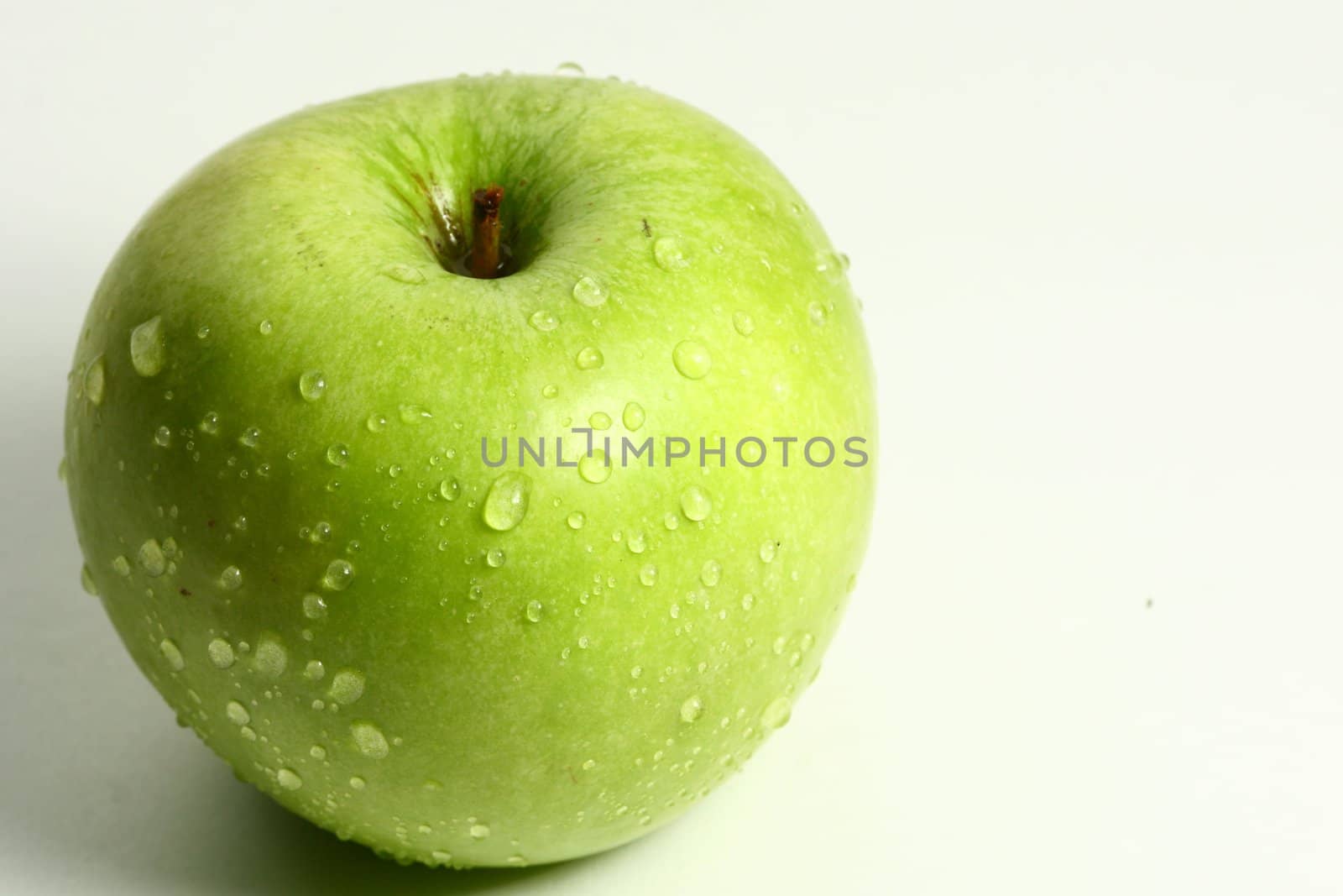 green fresh apple and waterdrops from it