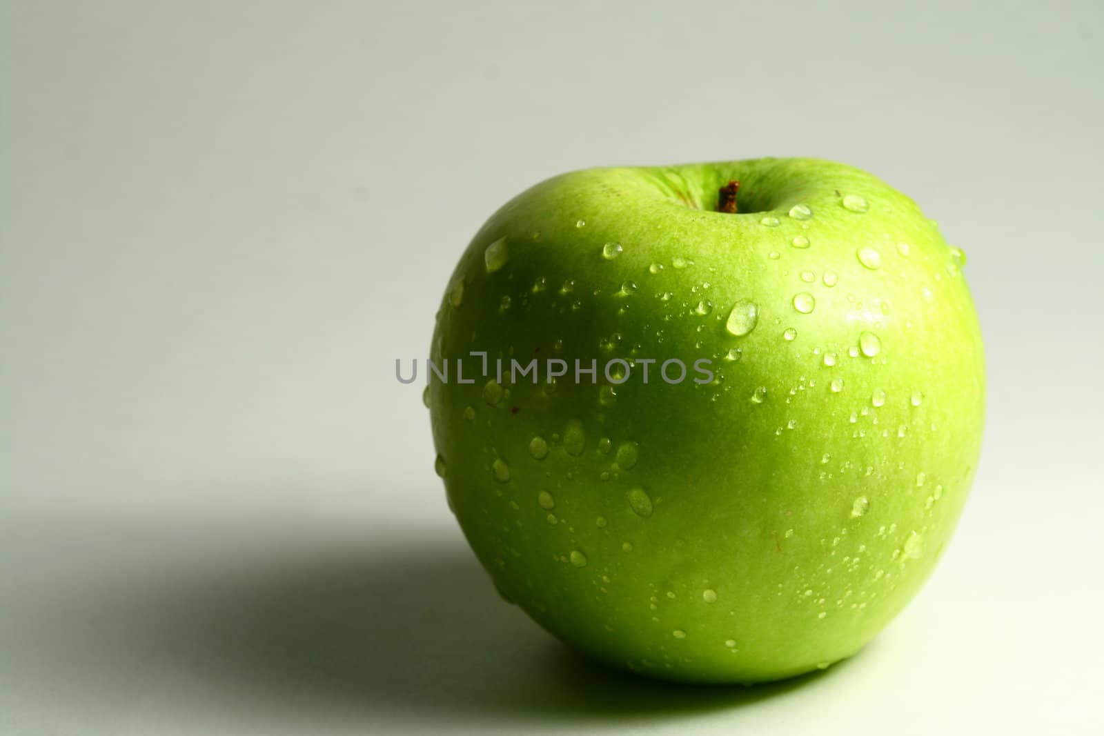 green fresh apple and waterdrops from it