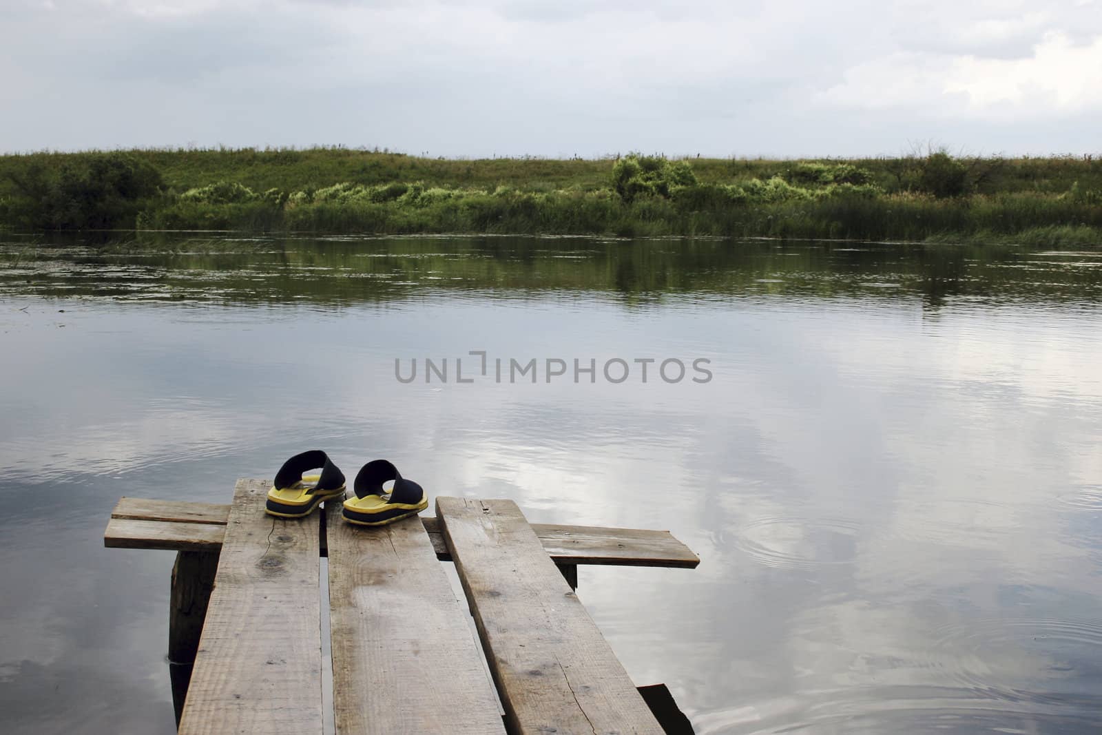 Yellow rubber slippers on wooden bridge