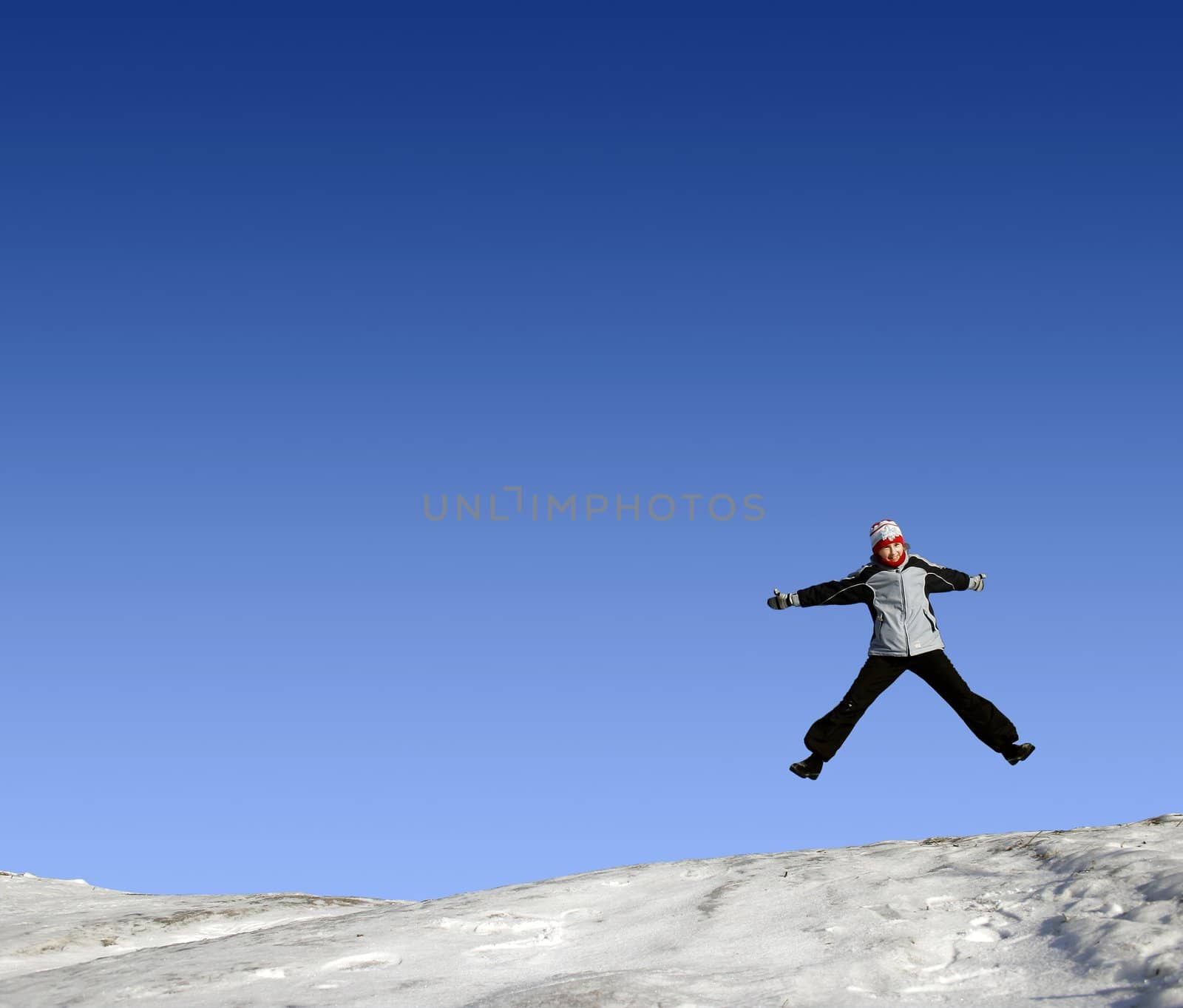 Little child jumping in the air in winter cloth.