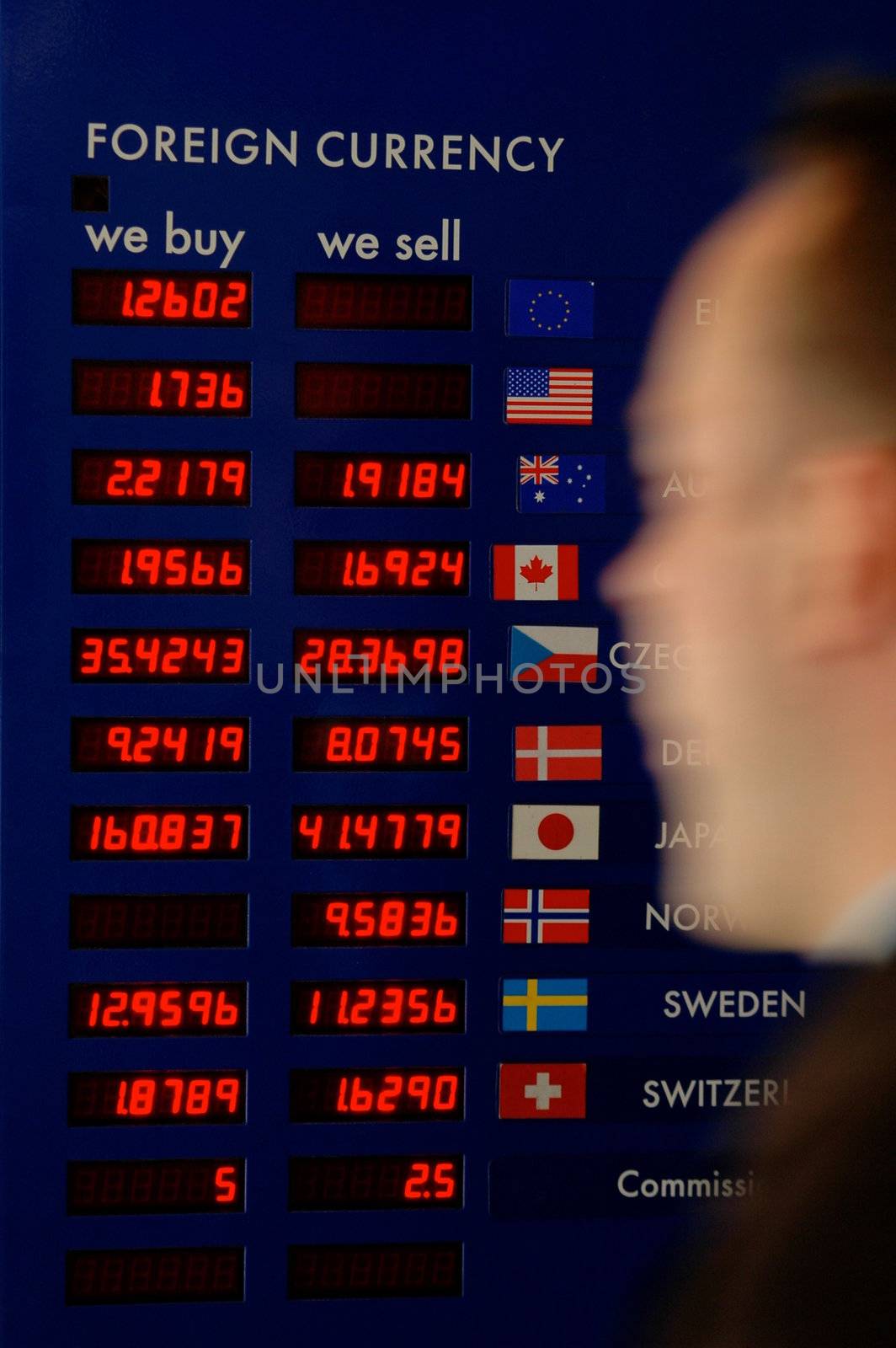 A man rushing past a currency board at an airport or station