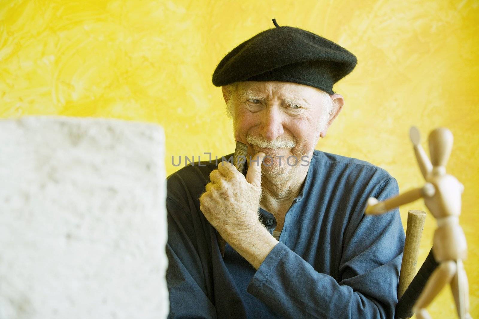 Artist ponders a wooden figure model