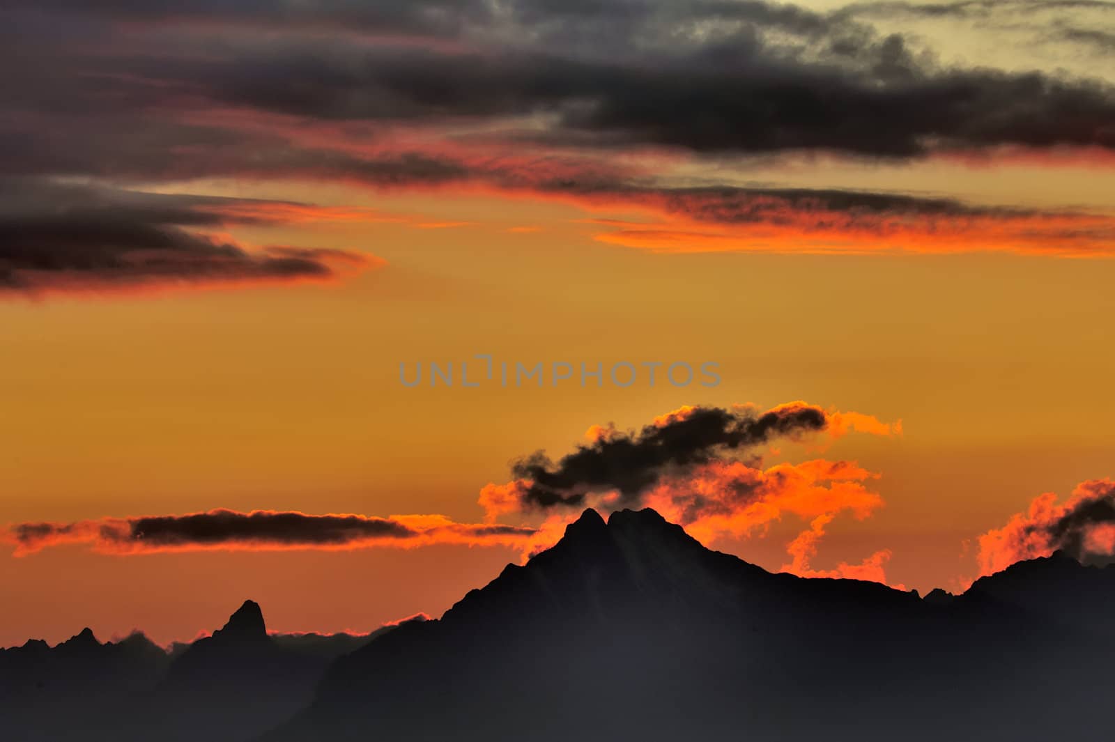 Clouds over the Swiss Alps, illuminated by the last rays of the setting sun.