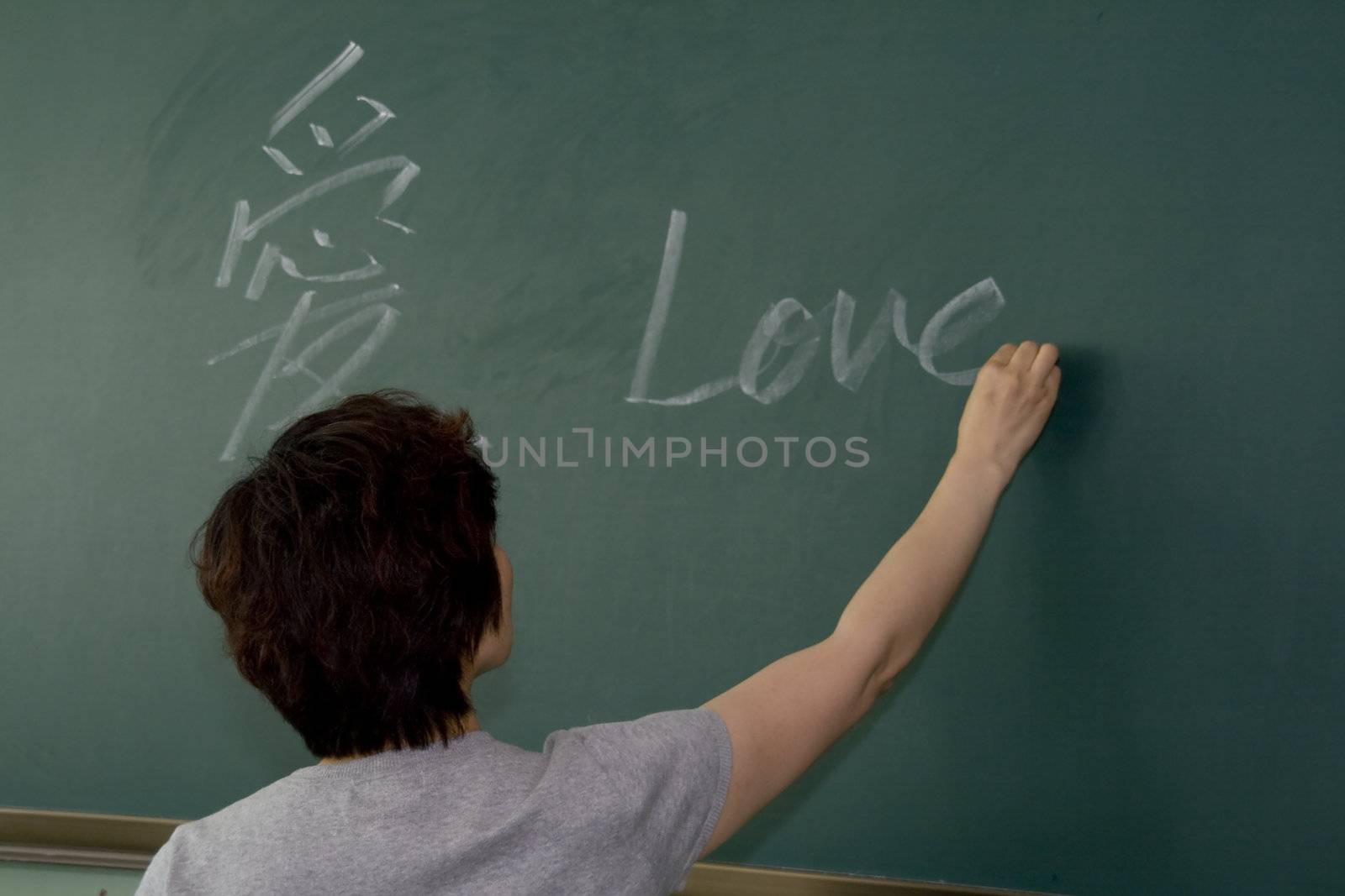 Female teacher writing on a blackboard 