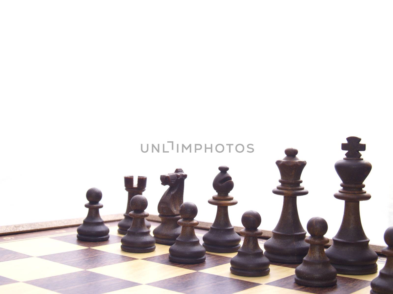 black chessmen on chess board in the beginning of game