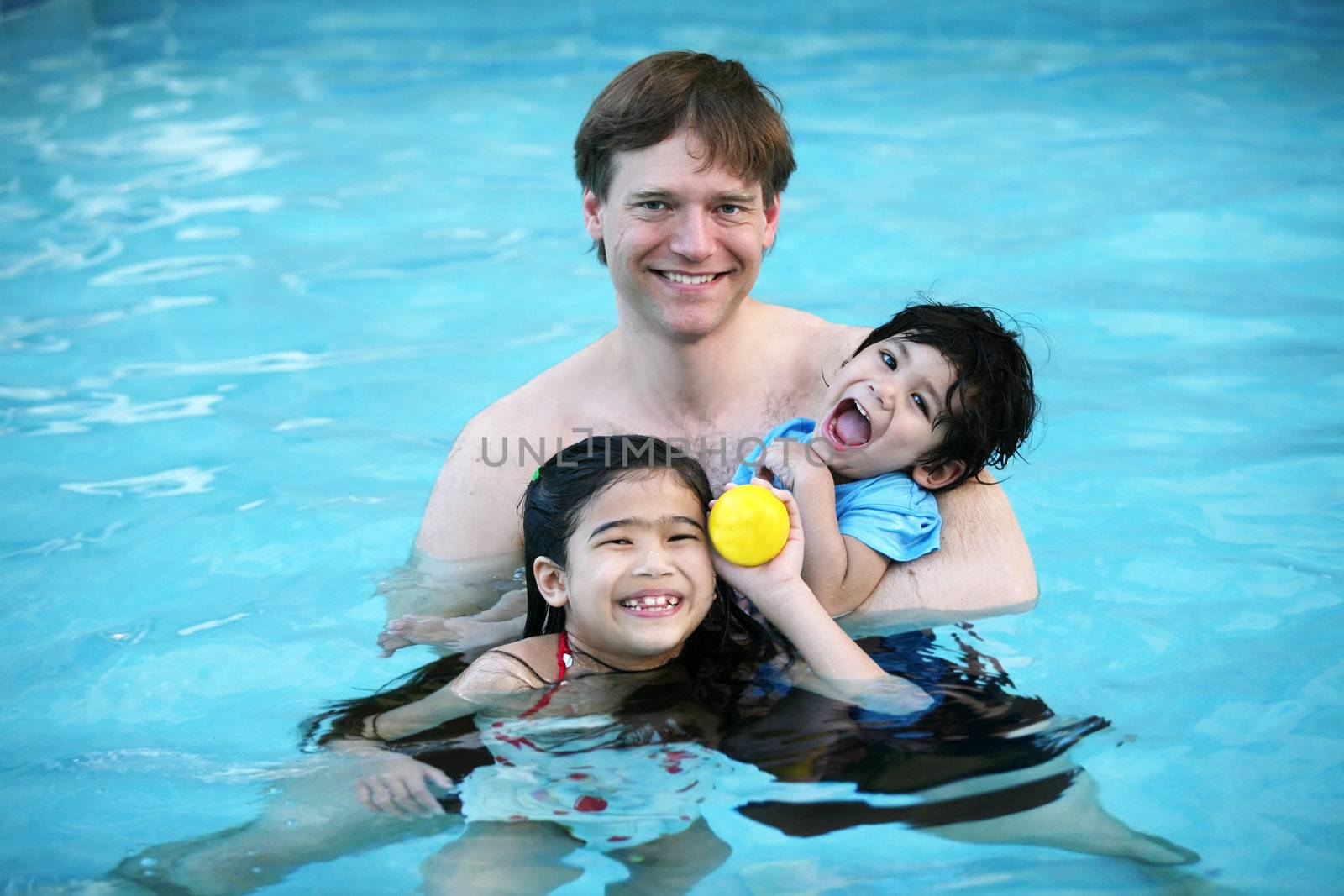 Father and his two children enjoying the pool