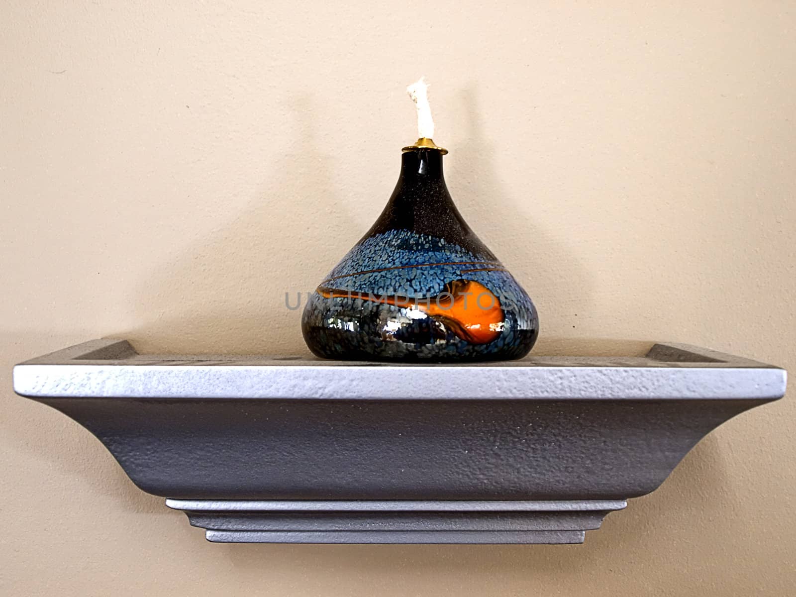 Decorative oil lamp on a shelf.
