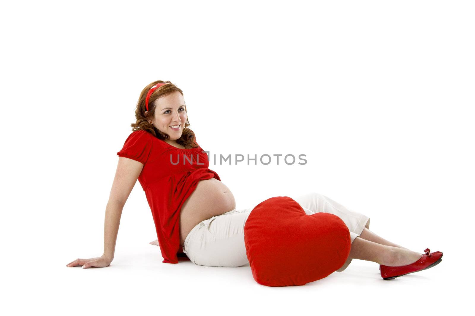 Beautiful pregnant woman enjoying this wonderful moment with a red Heart