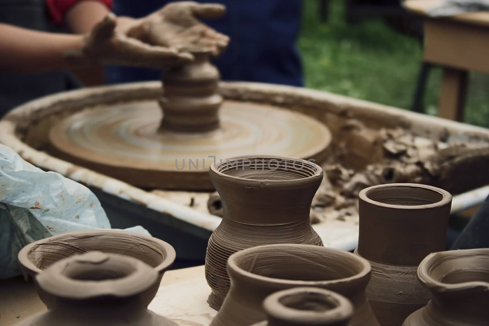 Potter working with clay bowl on potter's wheel