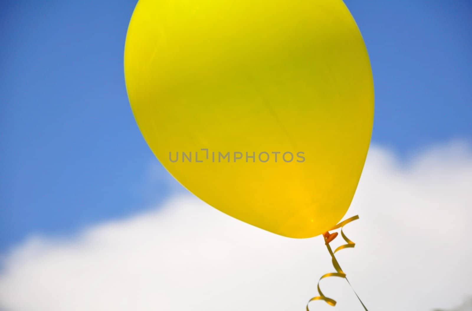 A single yellow balloon floats up and away.