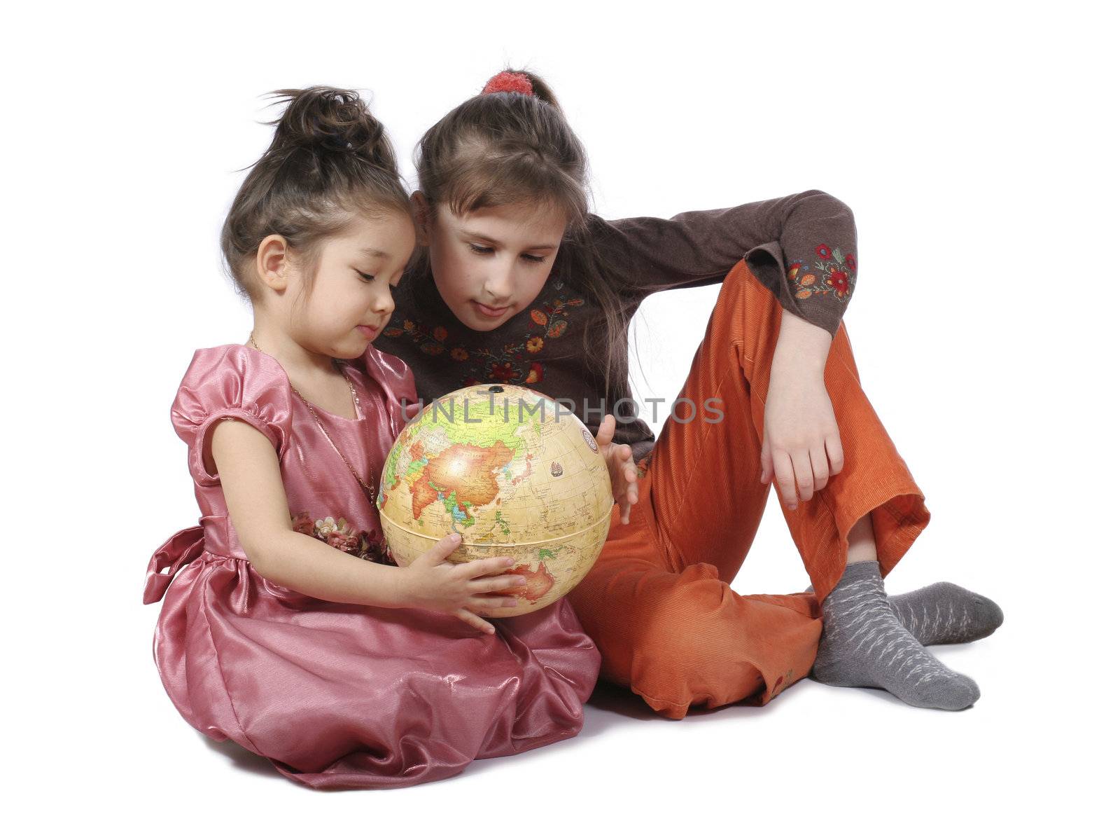 Two girls consider globe on white background
