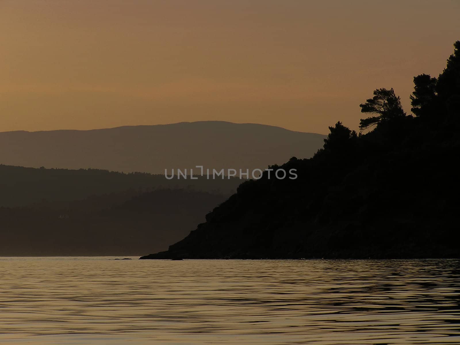 Landscape at sunset with reflection in sea water.