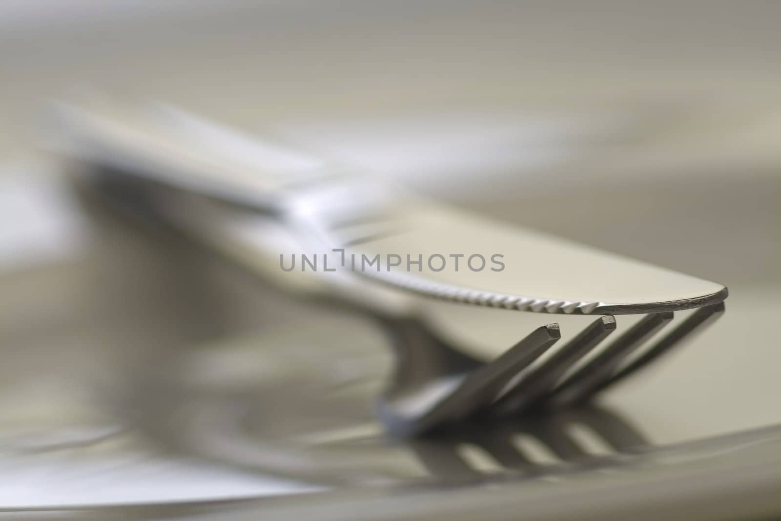 Fork and knife on white background in close-up view. Soft-focus.