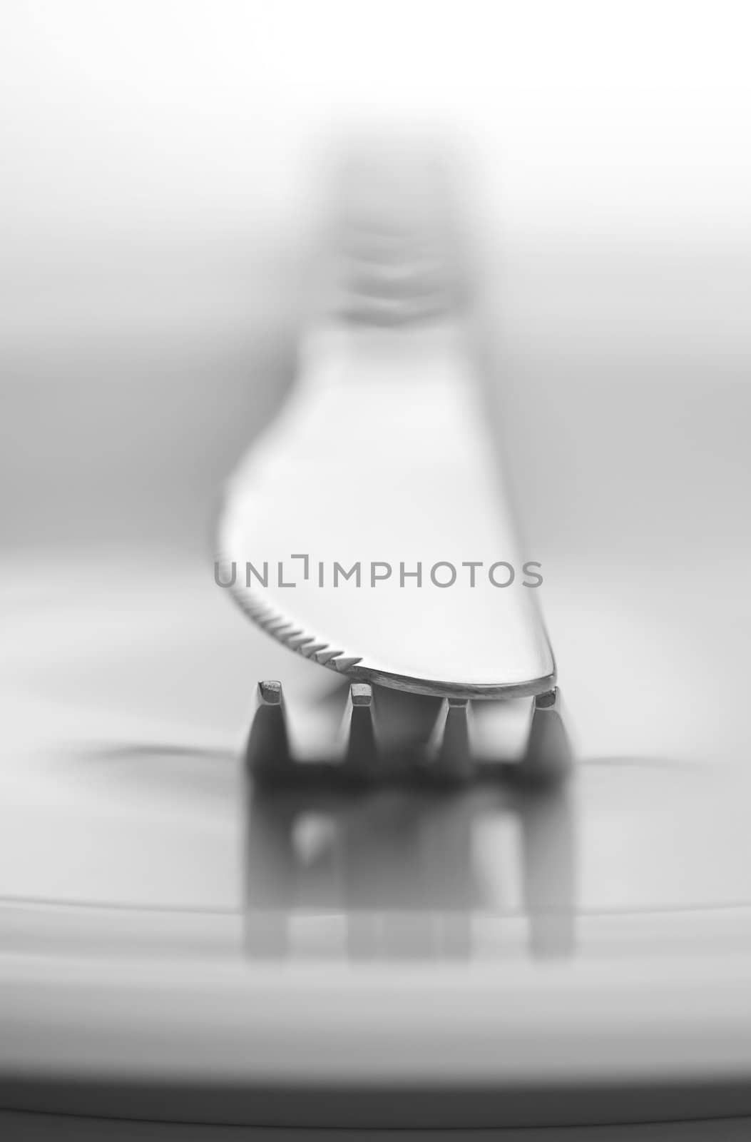 Fork and knife on white background in close-up view. Soft-focus.