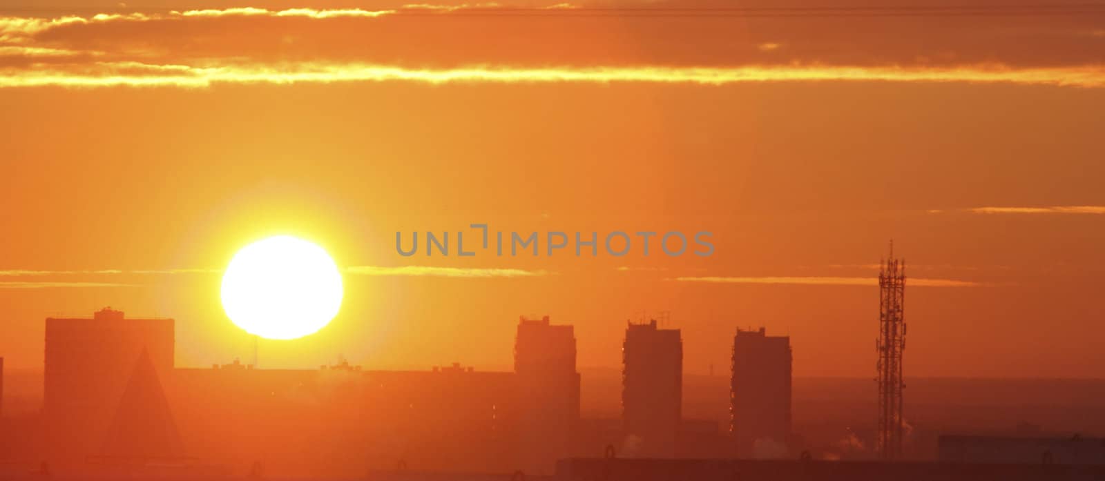 The Yellow sunrise on matutinal city with silhouette of the alive houses.