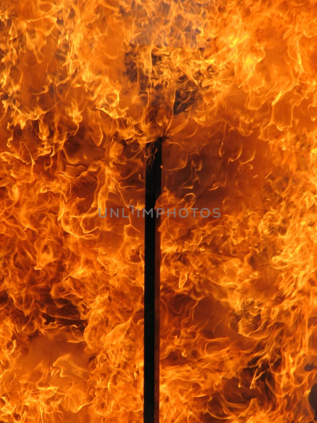 house on fire, flames coming through a window flame