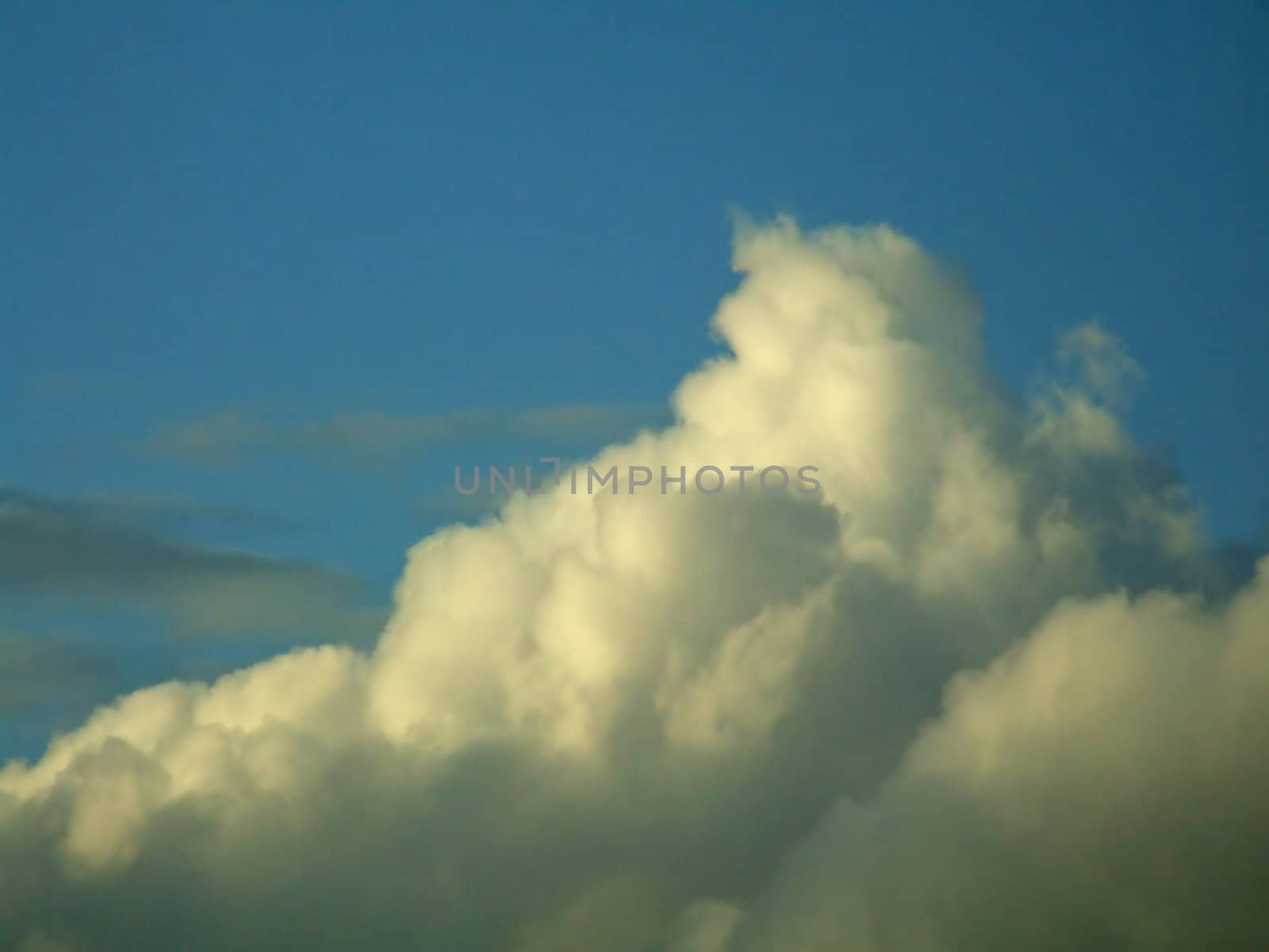 Clouds in evening with sunlight, shadows and blue sky