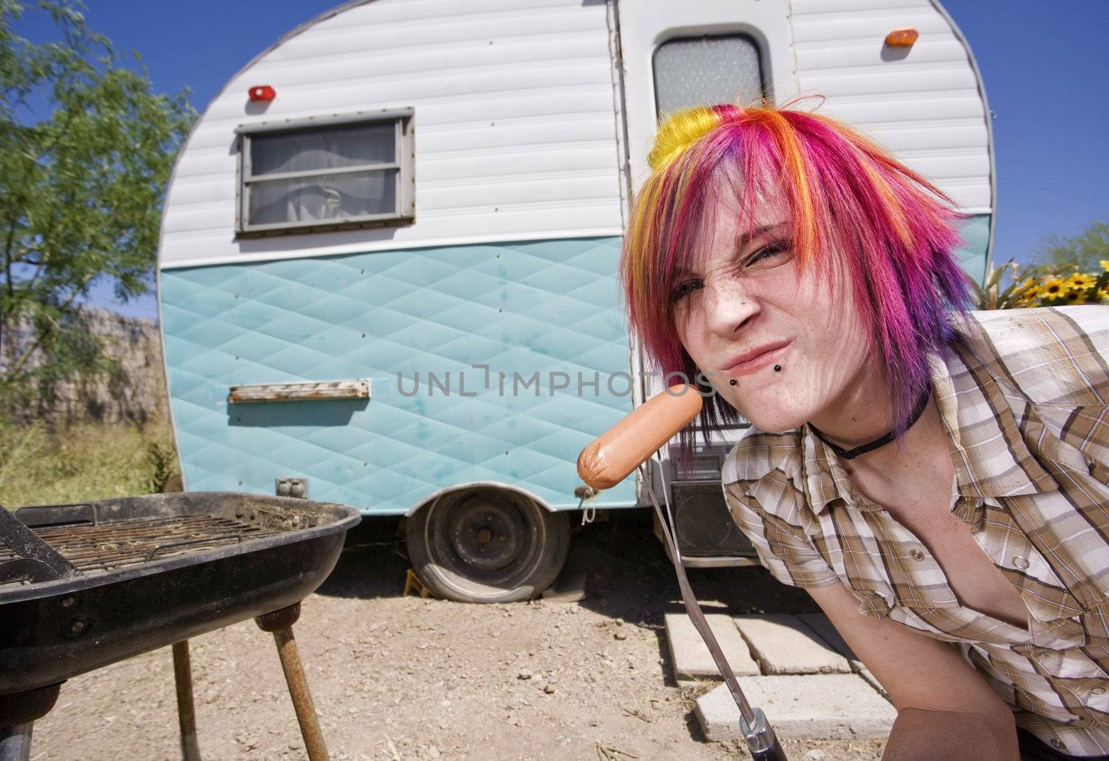 Girl in front of a trailer with a hotdog and a barbecue