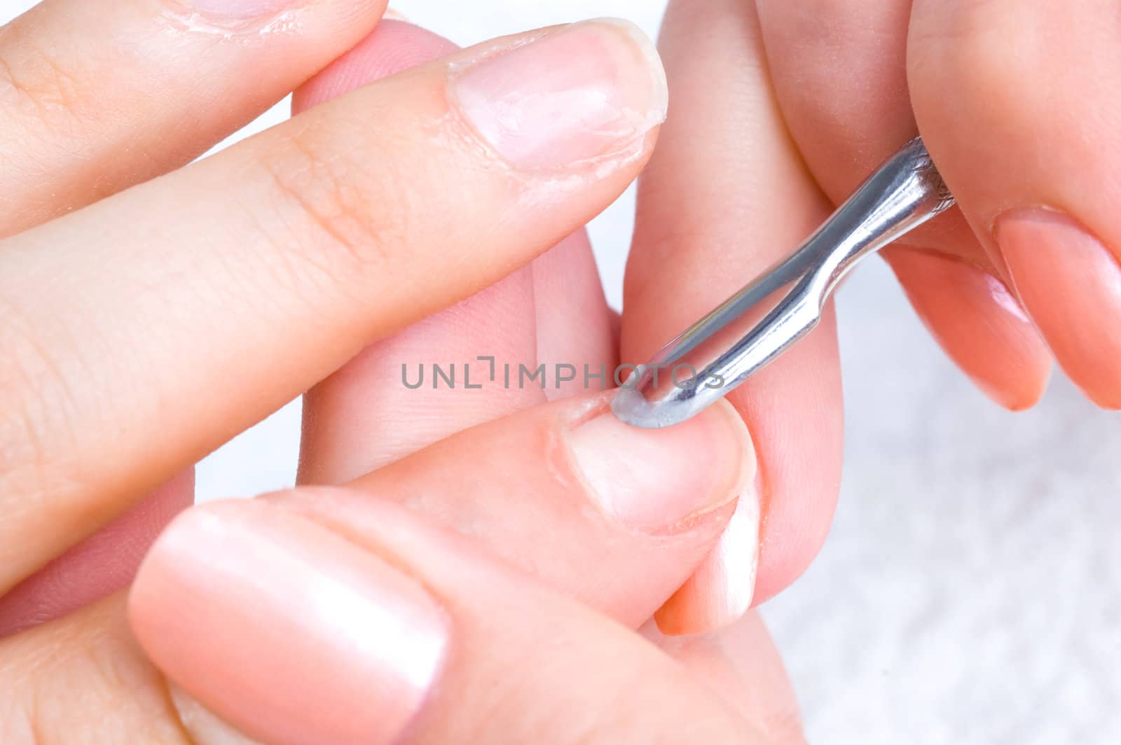 manicure applying - cleaning the cuticles with special istrument