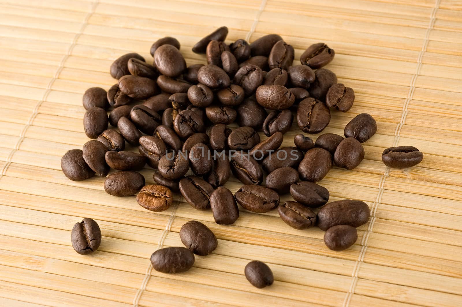 Coffee beans on a bamboo mat, close up.