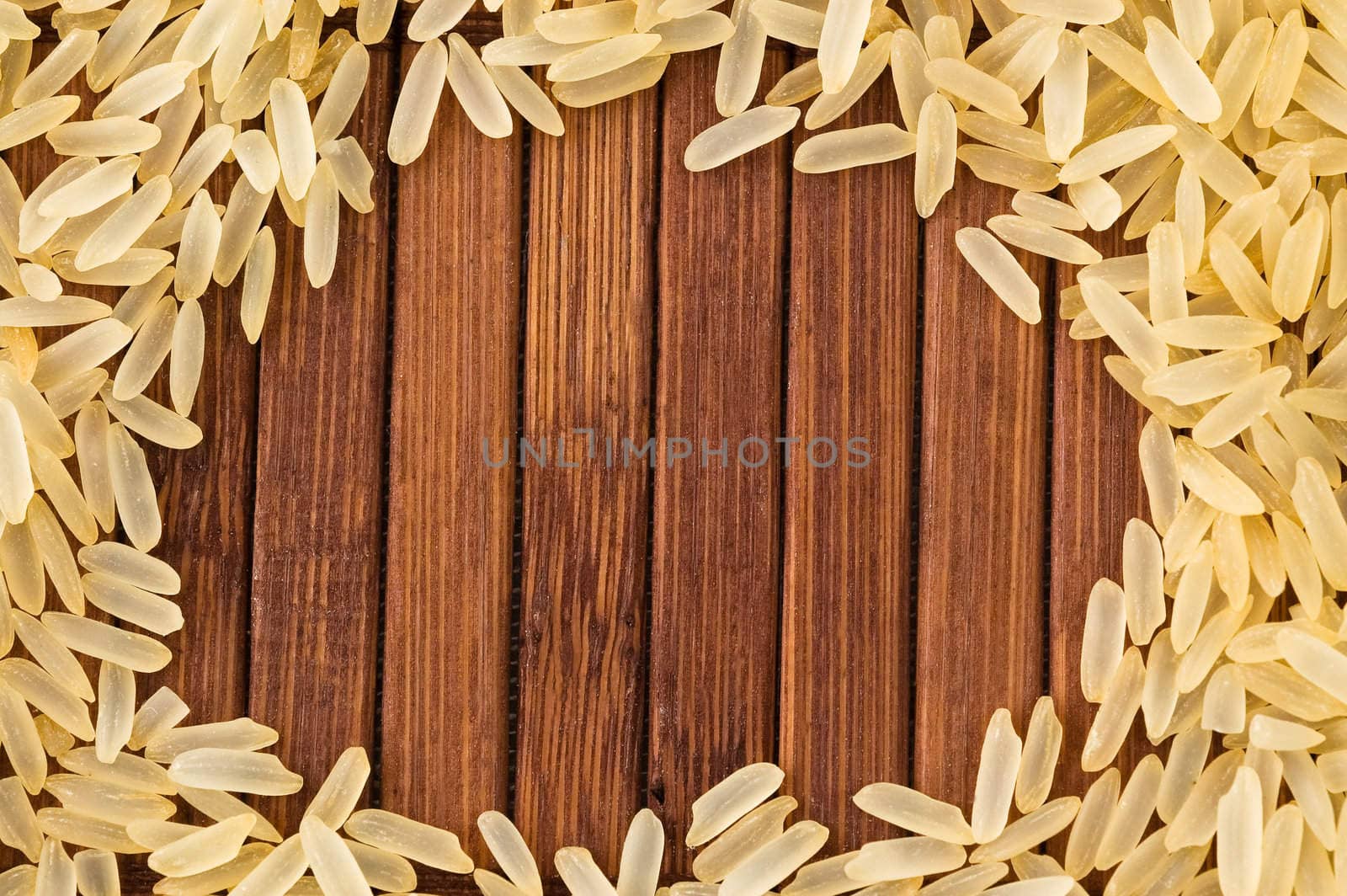 Frame of uncooked rice on bamboo mat with copy space.