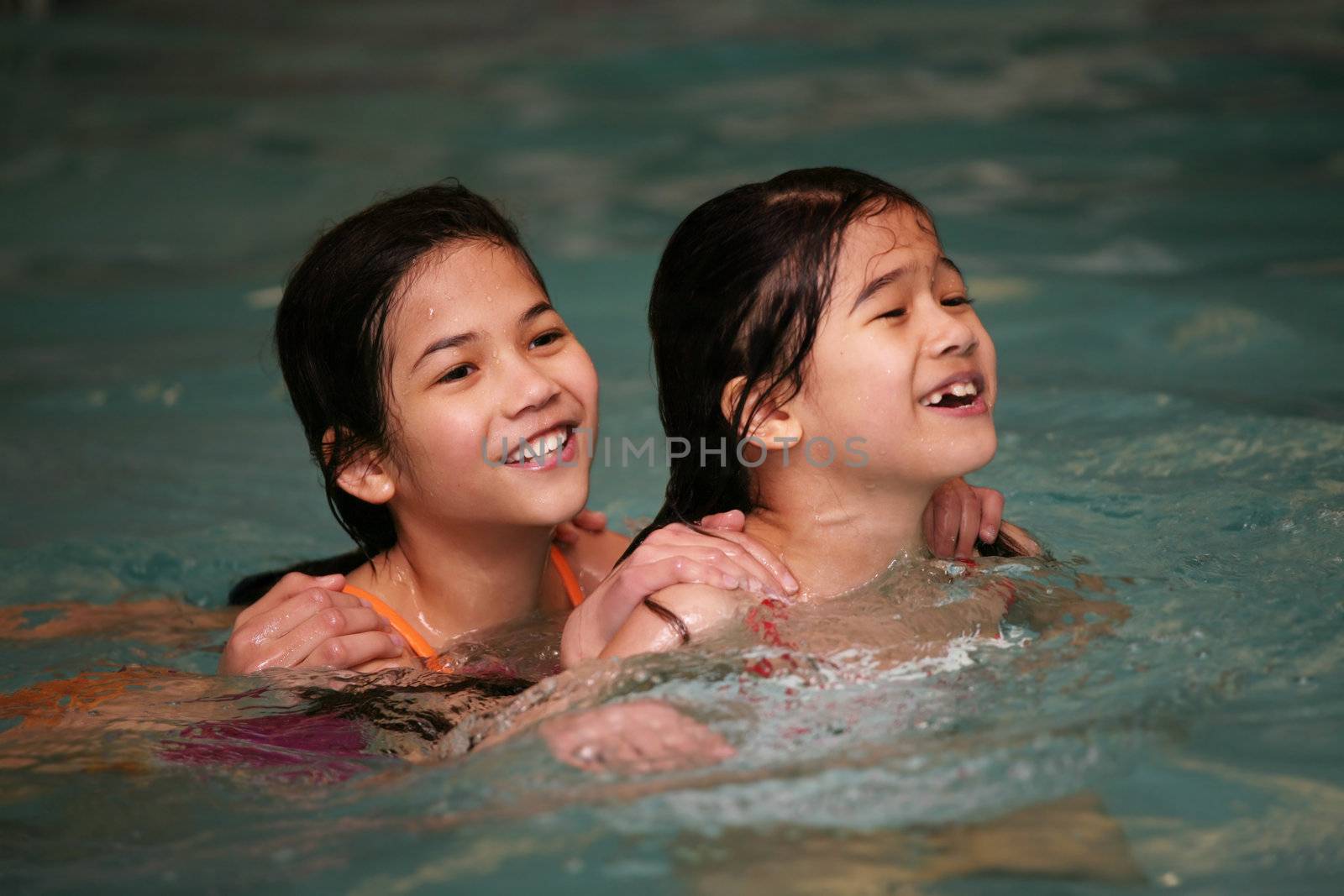Two girls in swimming pool by jarenwicklund