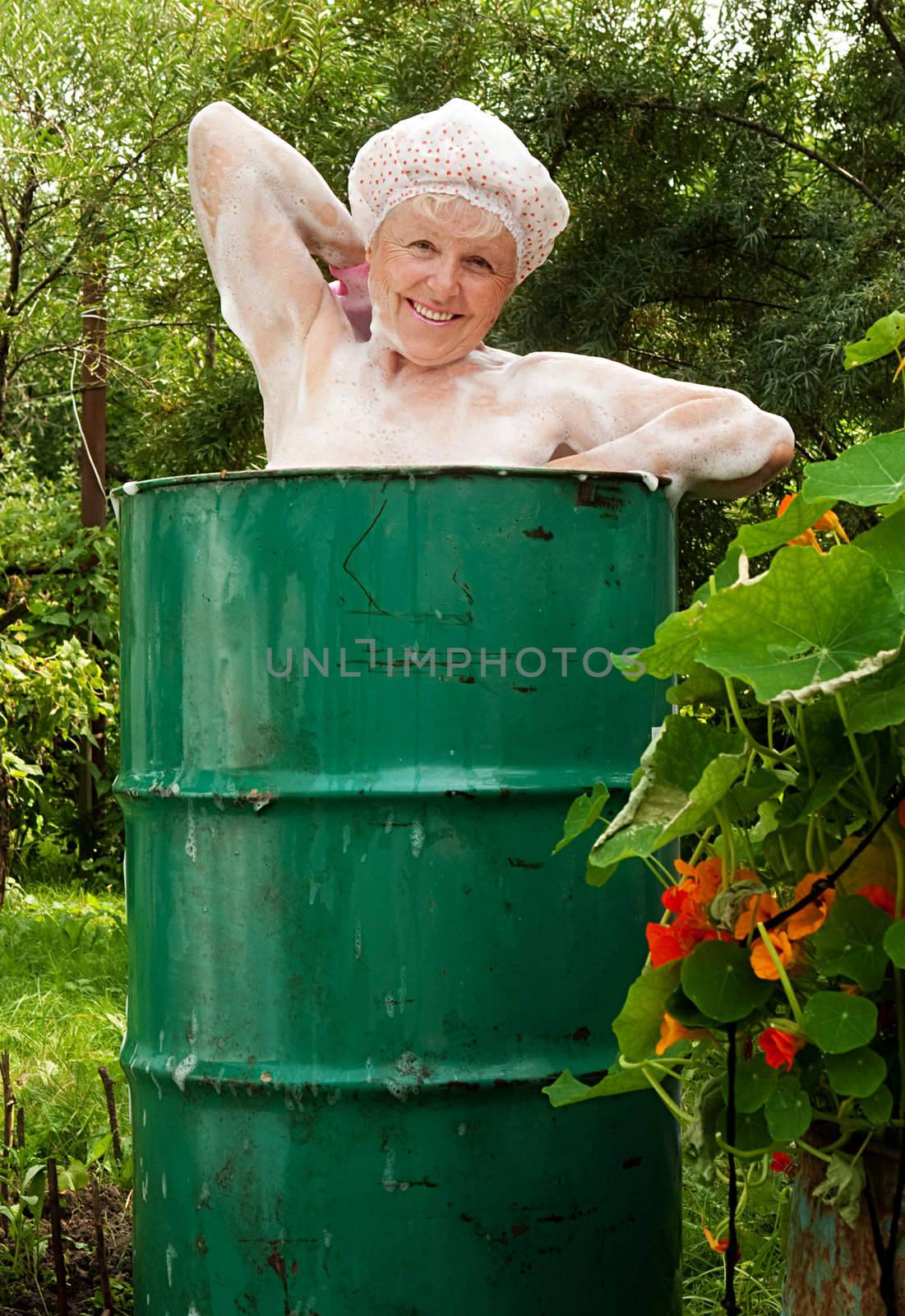 
The elderly woman washes in the cask
