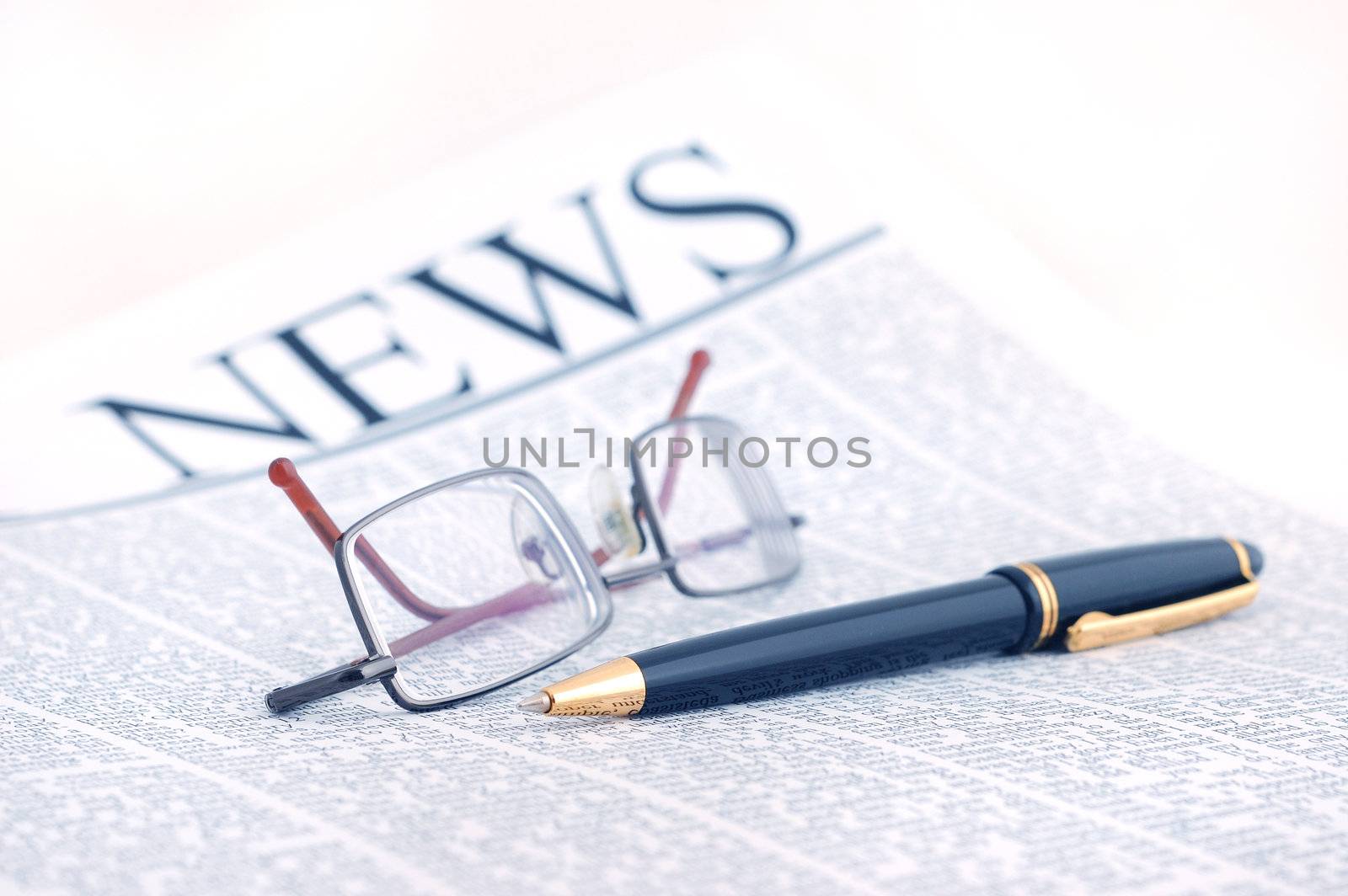 smart glasses and pen on newspaper page
