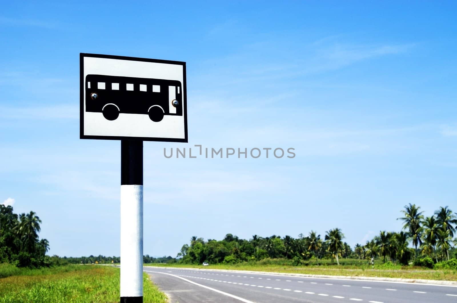 A bus stand signpost on a deserted road.  