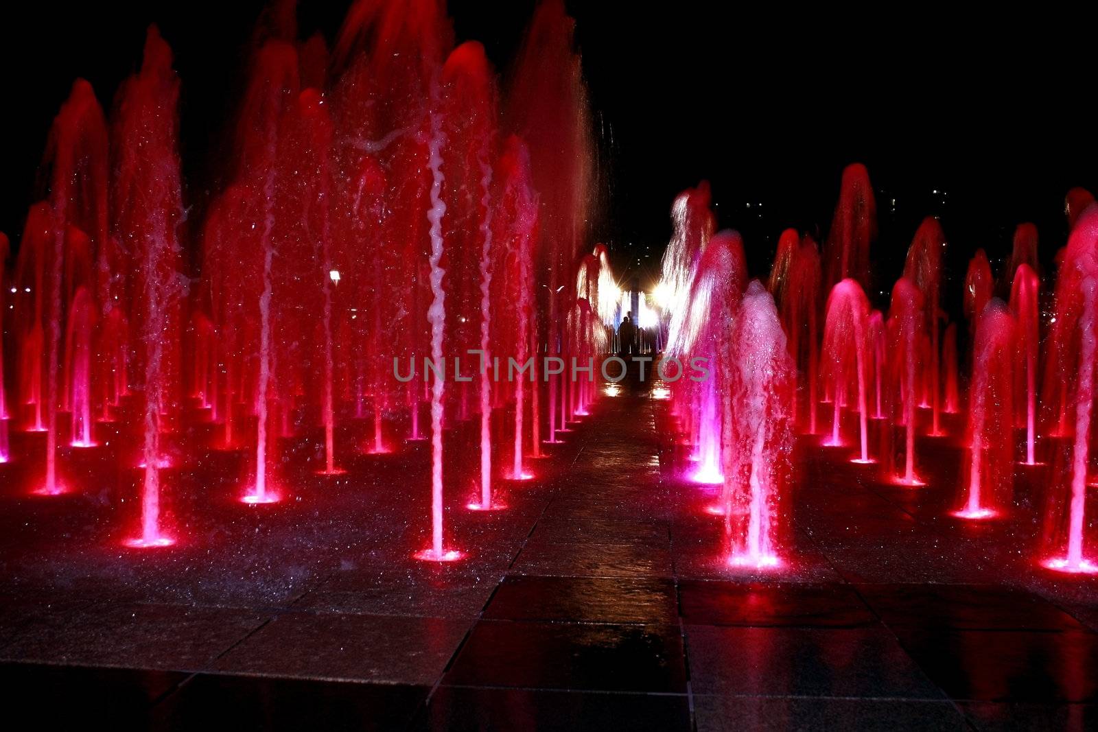 Colorful Fountain with People Silhouettes at night