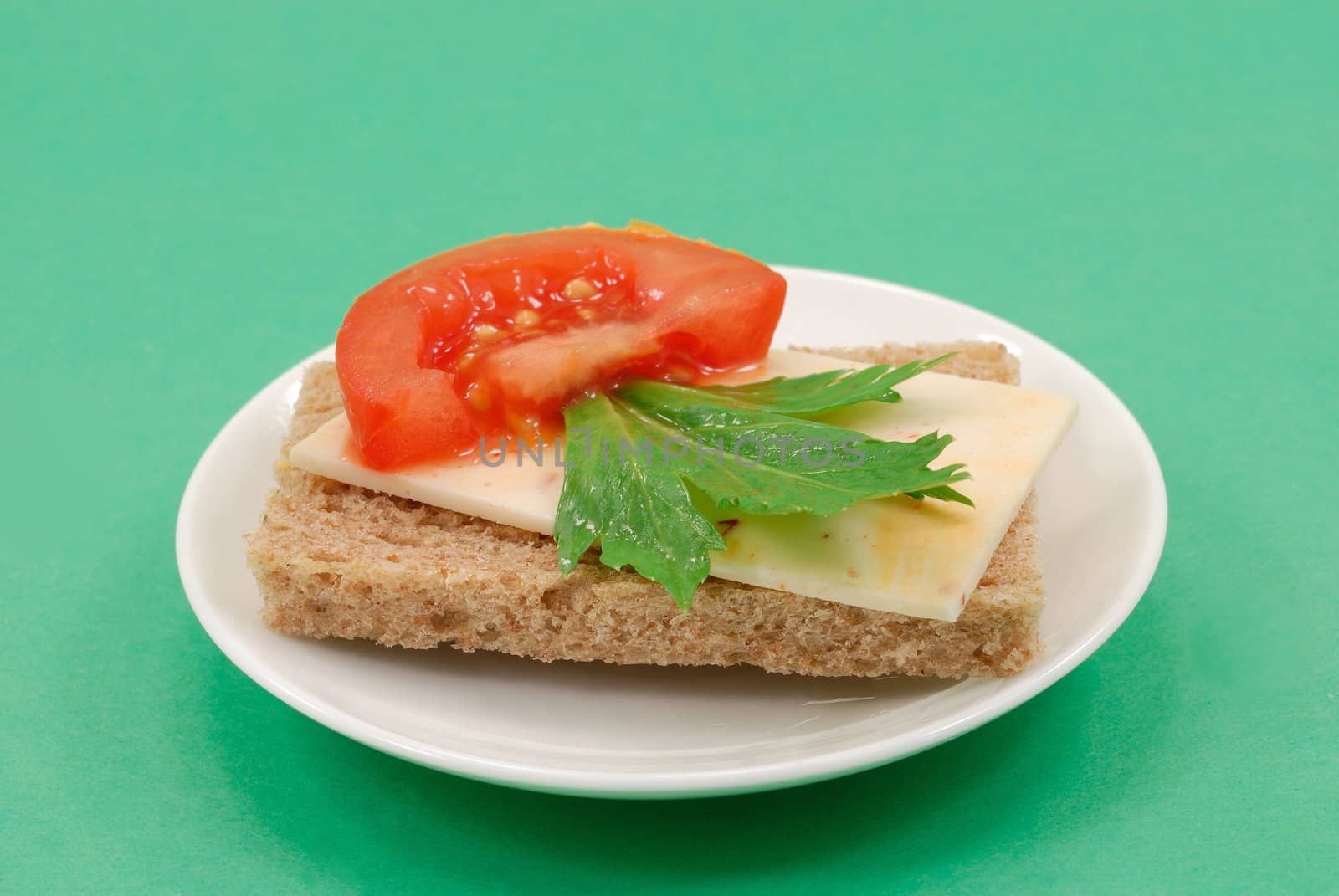 Buterbrob with Mexican cheese, slice tomatoes and green leaves of parsley
